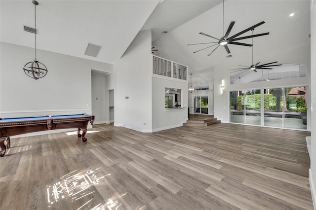 interior space featuring pool table, ceiling fan with notable chandelier, hardwood / wood-style floors, and high vaulted ceiling