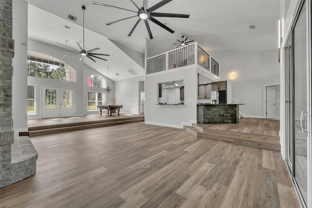 unfurnished living room featuring french doors, pool table, hardwood / wood-style floors, and high vaulted ceiling