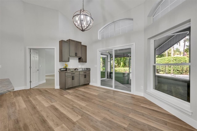 unfurnished living room featuring light wood-type flooring, high vaulted ceiling, and plenty of natural light