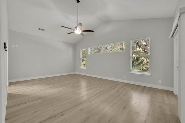 empty room with high vaulted ceiling, light hardwood / wood-style floors, and ceiling fan