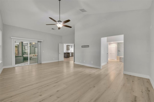 unfurnished living room with light wood-type flooring, ceiling fan, and high vaulted ceiling