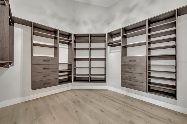 walk in closet with light hardwood / wood-style floors