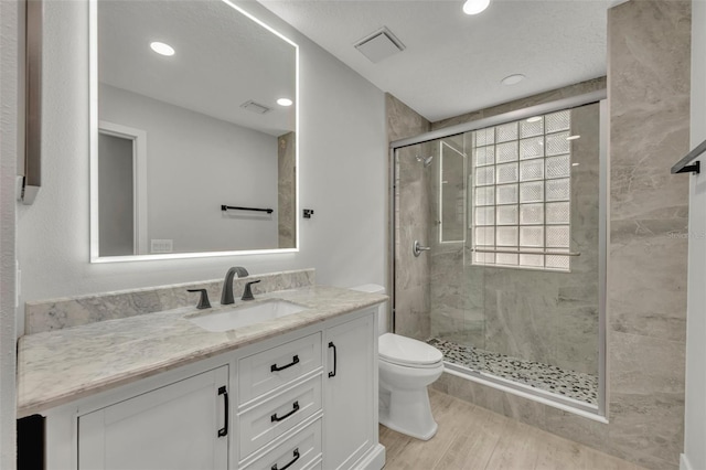 bathroom with walk in shower, vanity, toilet, and hardwood / wood-style flooring