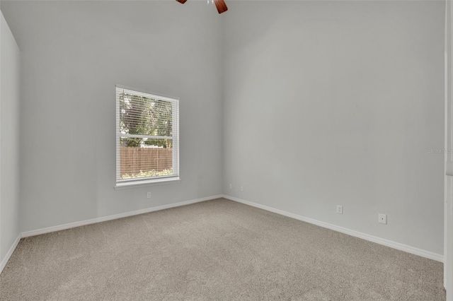 carpeted spare room featuring ceiling fan