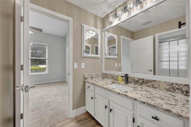 bathroom featuring a textured ceiling, vanity, and hardwood / wood-style floors