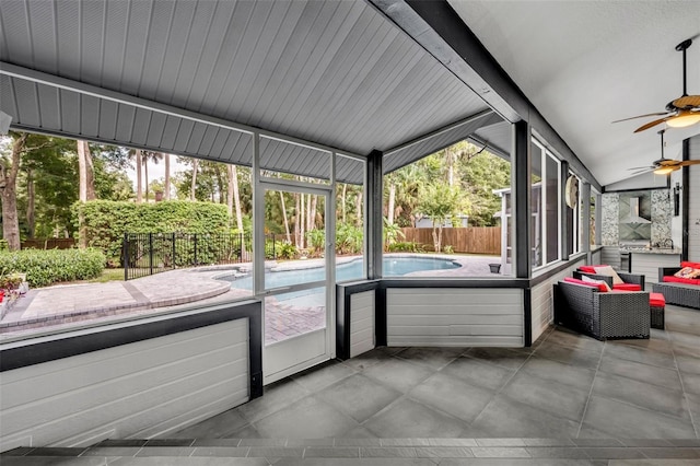 unfurnished sunroom featuring lofted ceiling, ceiling fan, and plenty of natural light