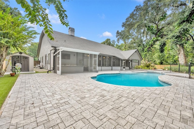 view of swimming pool with a patio, a storage shed, and a sunroom