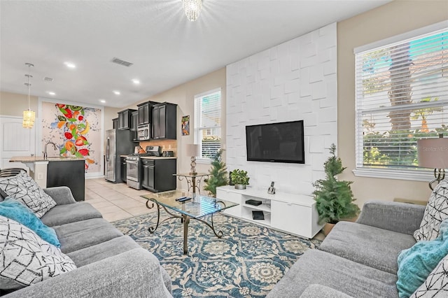 living room with light tile patterned flooring, sink, and a notable chandelier