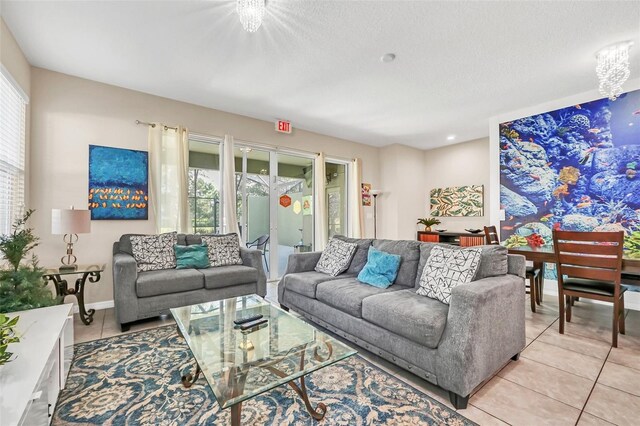 living room featuring a notable chandelier, light tile patterned floors, and a textured ceiling