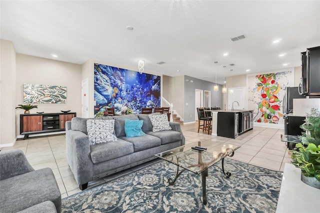 living room featuring sink and light tile patterned floors