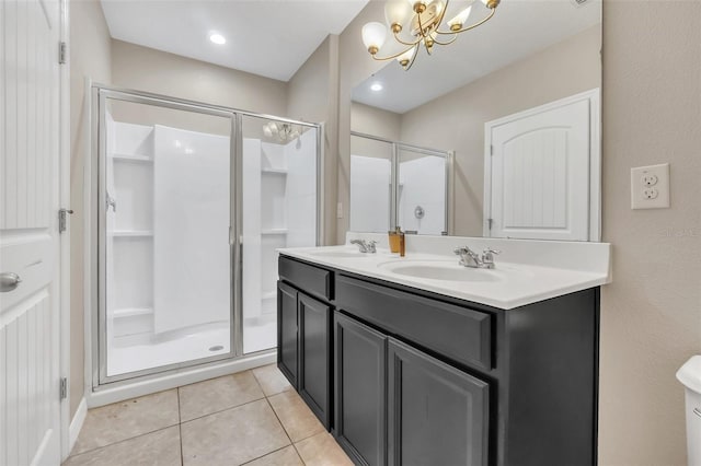 bathroom featuring an inviting chandelier, tile patterned flooring, a shower with door, and vanity