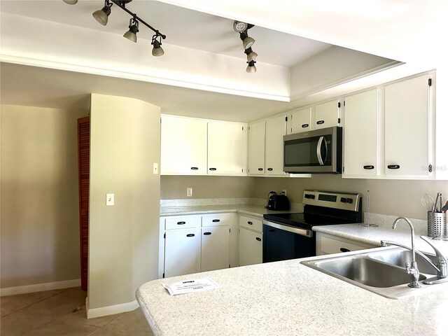 kitchen with white cabinetry, sink, light tile patterned floors, kitchen peninsula, and stainless steel appliances