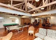 rec room with hardwood / wood-style floors, billiards, and a high ceiling