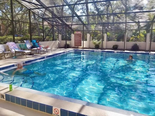 view of pool featuring a patio and glass enclosure