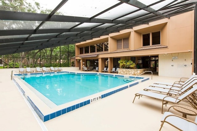 view of pool with a patio and glass enclosure