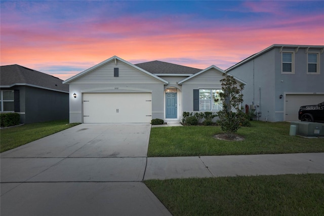 ranch-style house featuring a garage and a yard