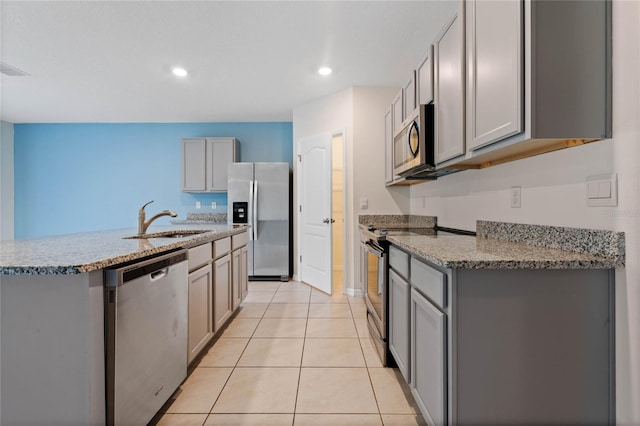 kitchen featuring light tile patterned floors, gray cabinets, appliances with stainless steel finishes, and sink