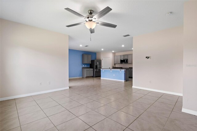 unfurnished living room featuring ceiling fan and light tile patterned flooring