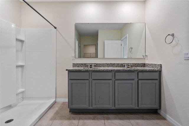 bathroom with a shower, vanity, and tile patterned floors