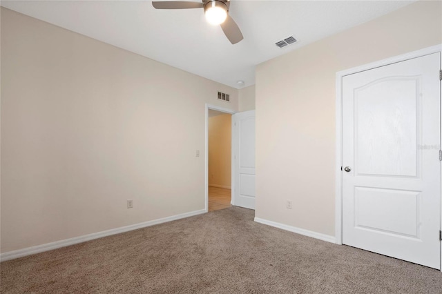 unfurnished bedroom with ceiling fan and light colored carpet