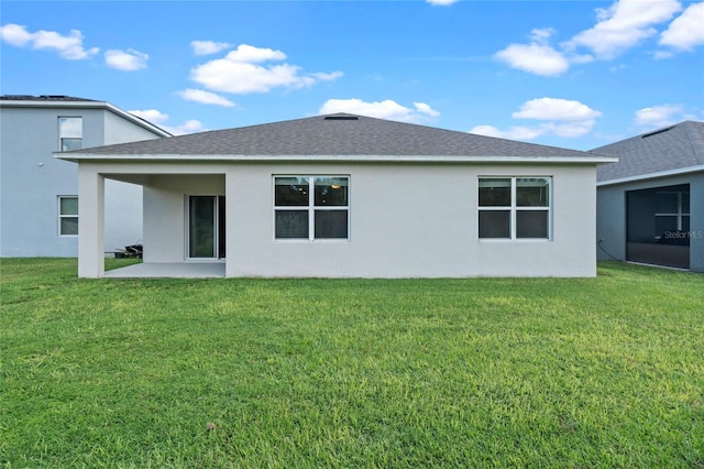 back of property featuring a sunroom, a patio area, and a yard