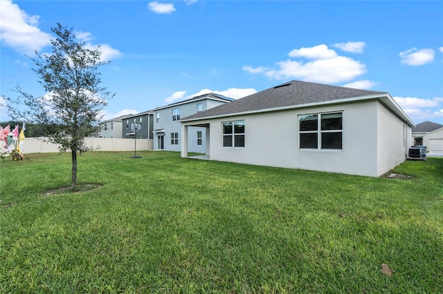 back of property with cooling unit and a yard