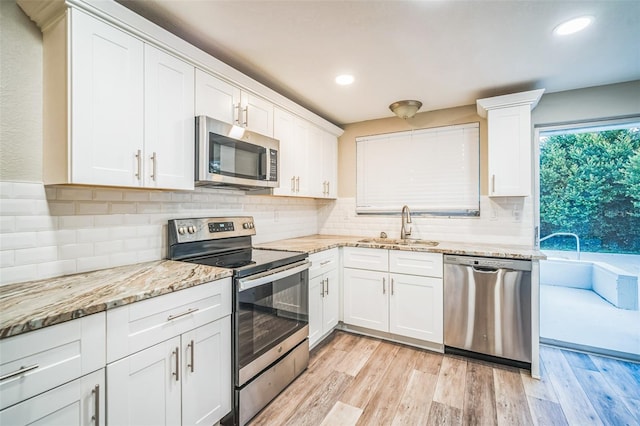 kitchen featuring light hardwood / wood-style flooring, stainless steel appliances, sink, and white cabinetry