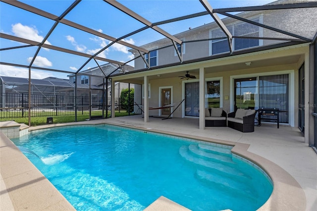 view of swimming pool featuring glass enclosure, ceiling fan, a patio area, and pool water feature