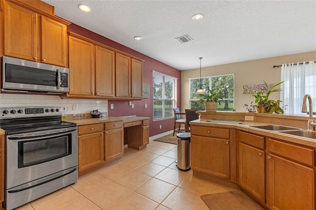 kitchen with decorative backsplash, appliances with stainless steel finishes, sink, hanging light fixtures, and light tile patterned flooring