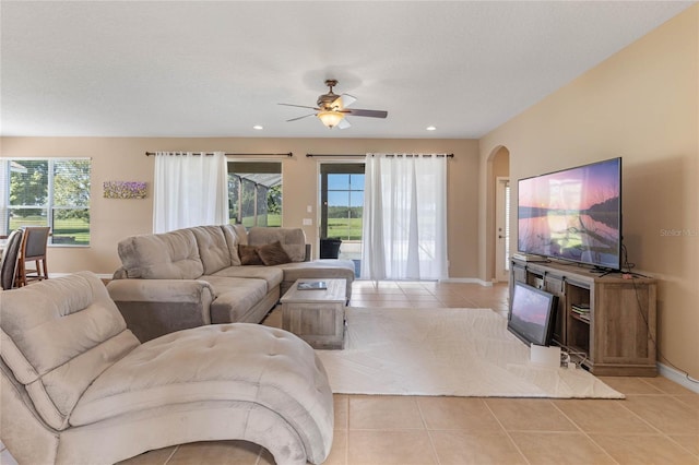 living room featuring ceiling fan, light tile patterned flooring, and a textured ceiling