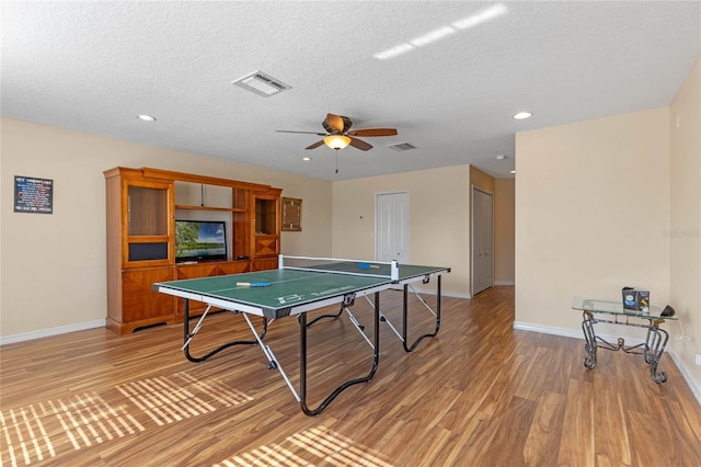 rec room with a textured ceiling, hardwood / wood-style flooring, and ceiling fan