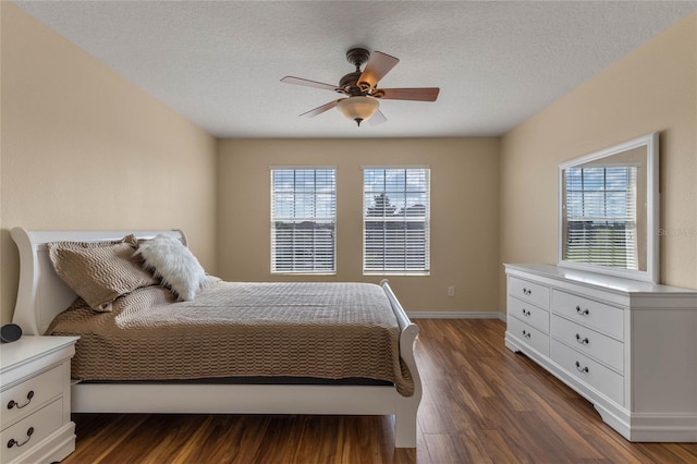 bedroom featuring a textured ceiling, dark hardwood / wood-style floors, multiple windows, and ceiling fan