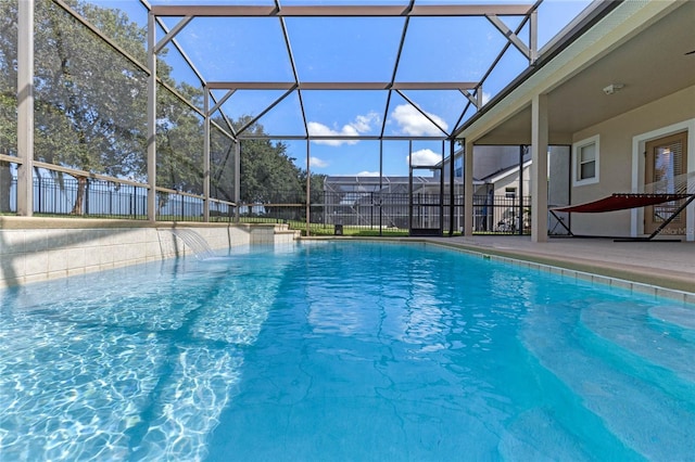 view of swimming pool with a patio, pool water feature, and glass enclosure