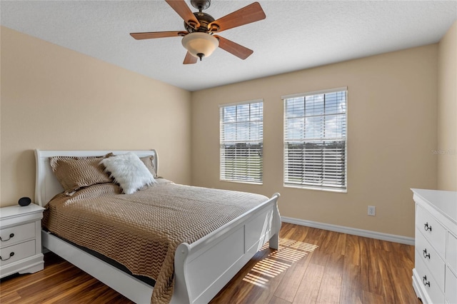 bedroom featuring a textured ceiling, ceiling fan, and dark wood-type flooring