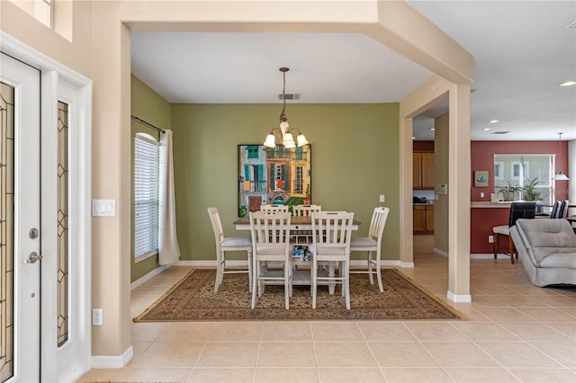 dining space with light tile patterned flooring and a chandelier