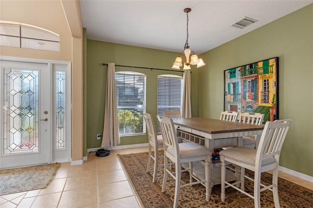 dining room with a notable chandelier and light tile patterned flooring