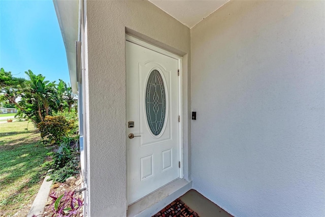 entrance to property featuring a lawn