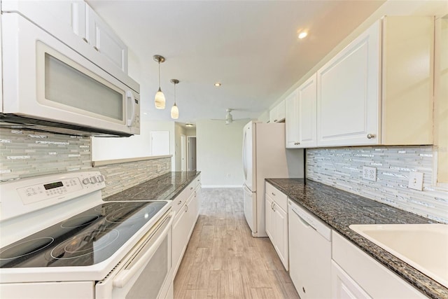 kitchen with white appliances, backsplash, decorative light fixtures, white cabinets, and light hardwood / wood-style flooring