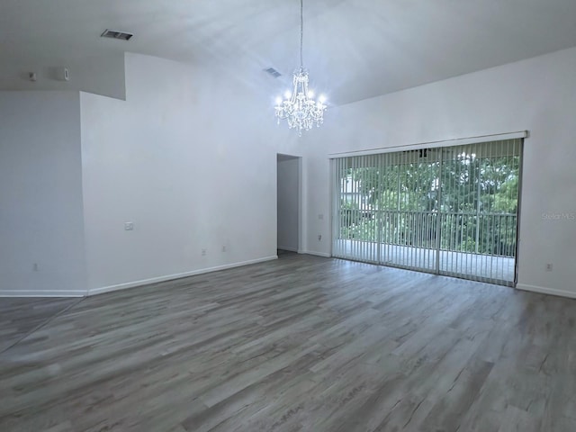 spare room featuring hardwood / wood-style floors and a notable chandelier