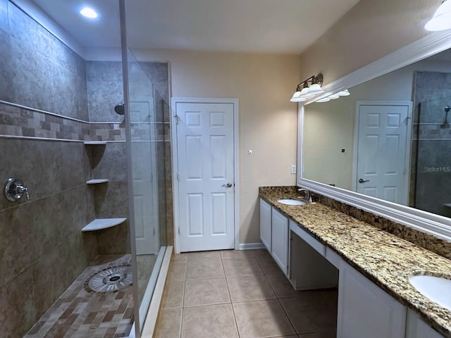 bathroom featuring vanity, tile patterned flooring, and a tile shower