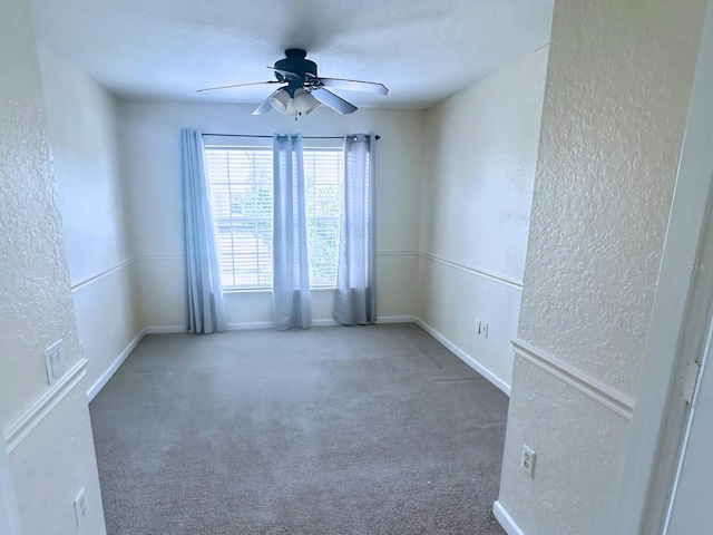 carpeted spare room with ceiling fan