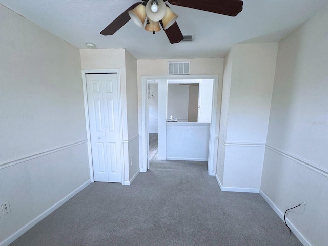 interior space with dark carpet, a closet, and ceiling fan