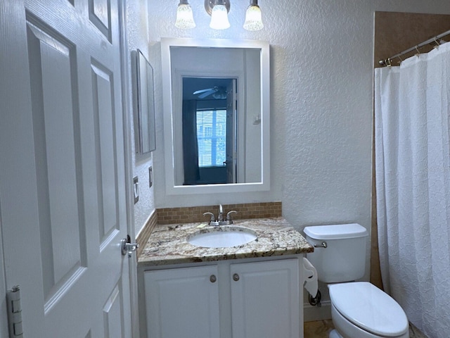 bathroom with vanity, toilet, and tasteful backsplash