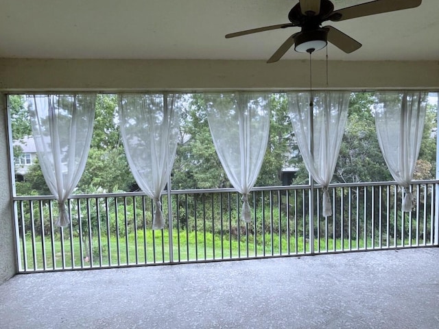 unfurnished sunroom with ceiling fan and plenty of natural light