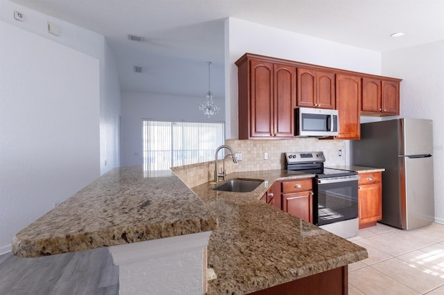 kitchen with stainless steel appliances, kitchen peninsula, sink, and backsplash