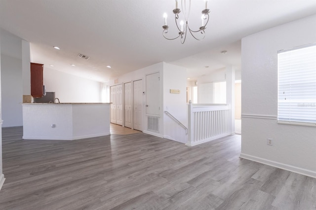 spare room with light hardwood / wood-style flooring and a chandelier