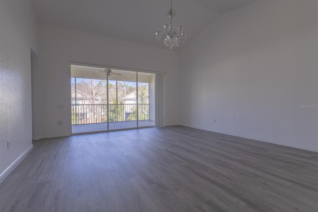 unfurnished room with wood-type flooring, high vaulted ceiling, and an inviting chandelier