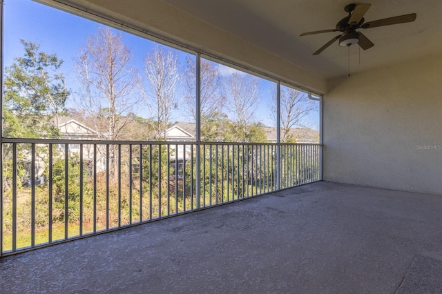 unfurnished sunroom with ceiling fan