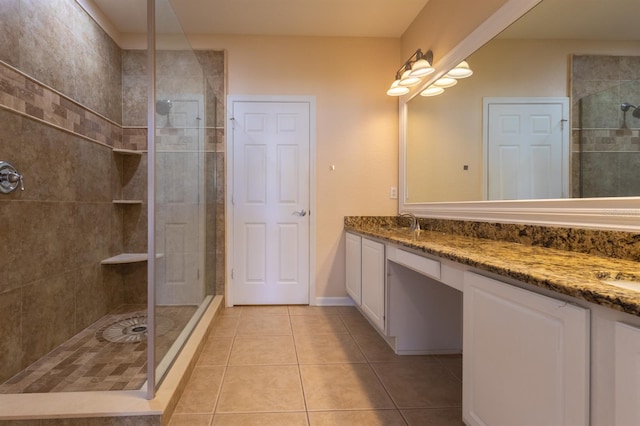 bathroom with an enclosed shower, vanity, and tile patterned floors