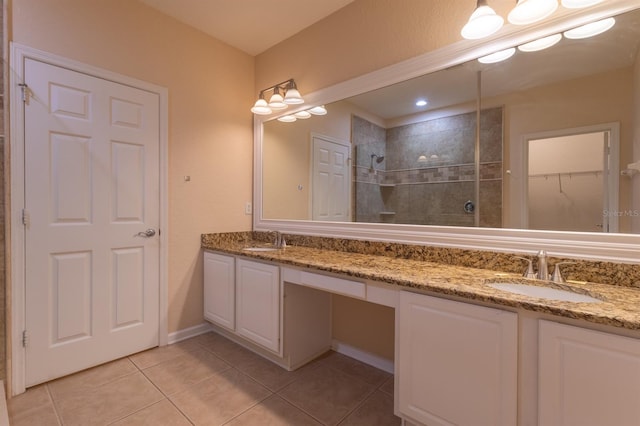 bathroom featuring tiled shower, vanity, and tile patterned floors